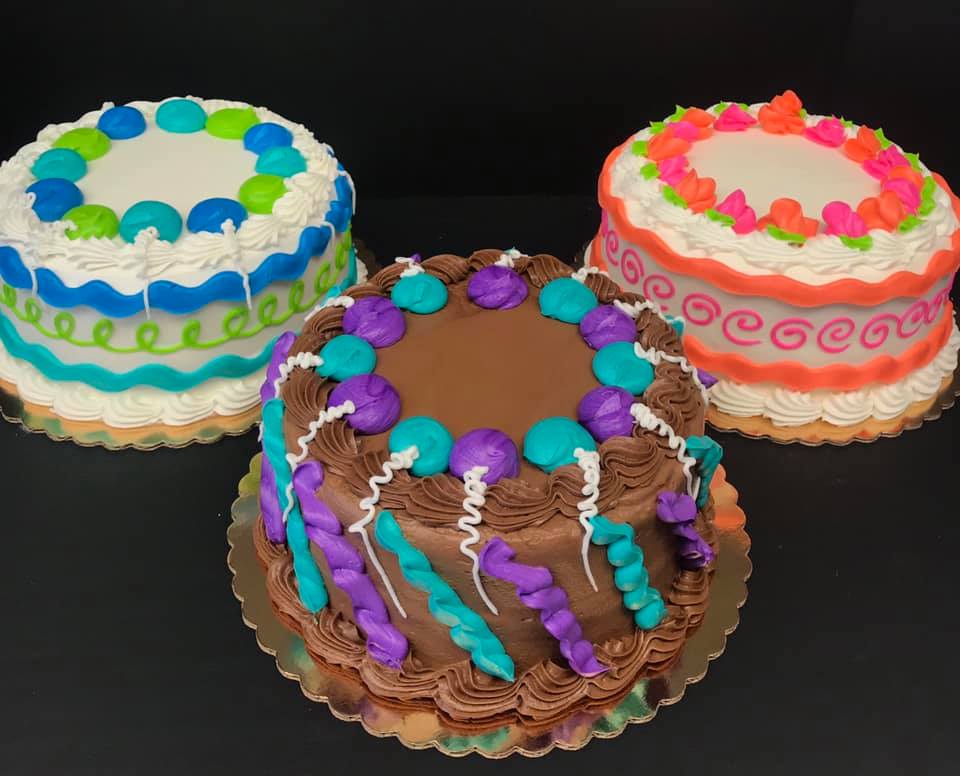 Three cakes decorated with different colors and decorations.