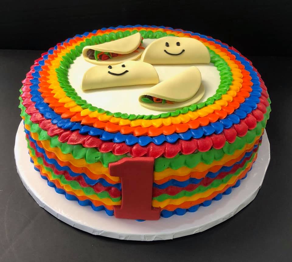 A cake decorated with tacos and a smiley face.