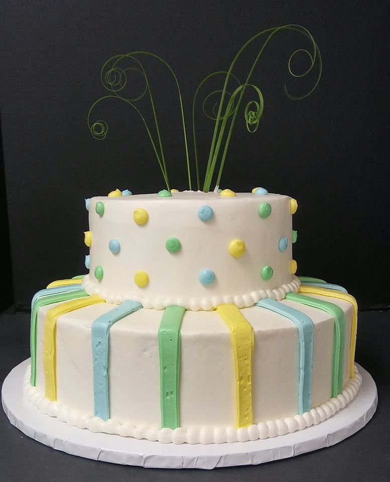 A three tier cake with green, yellow and blue stripes.