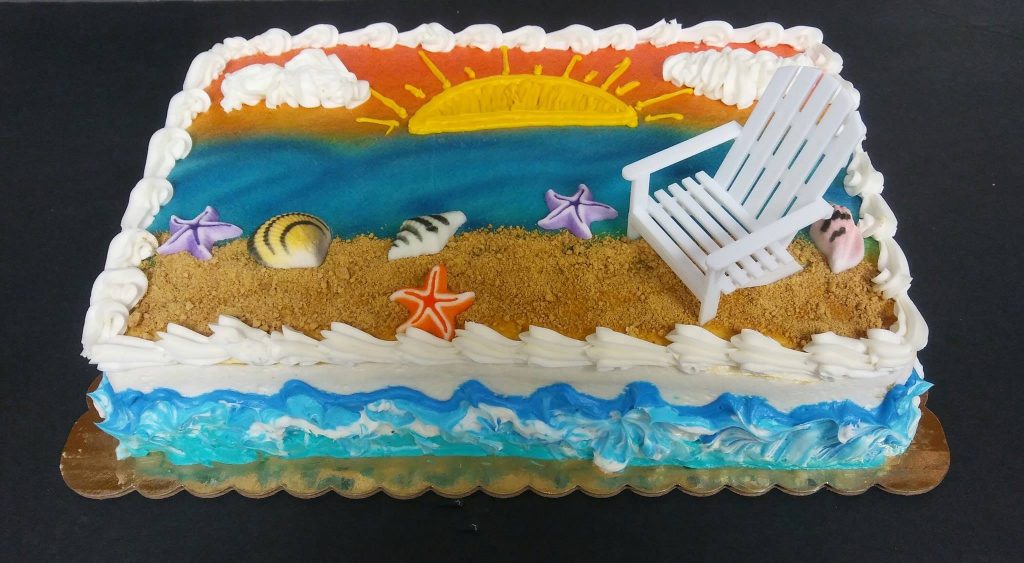 A cake decorated with a beach chair and seashells.