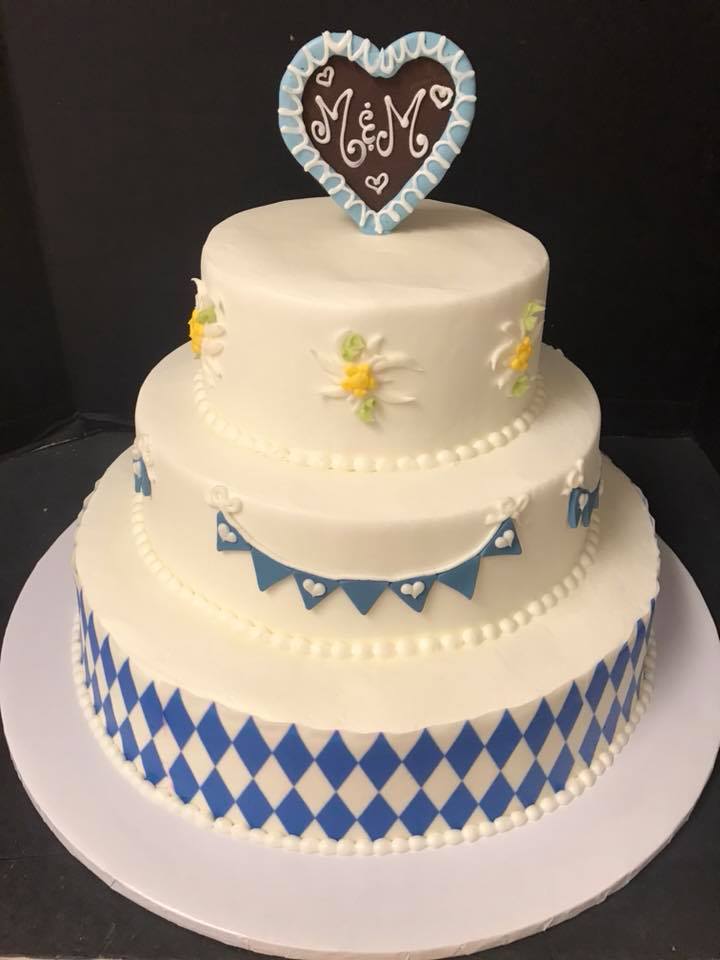 A blue and white cake with a heart on top.