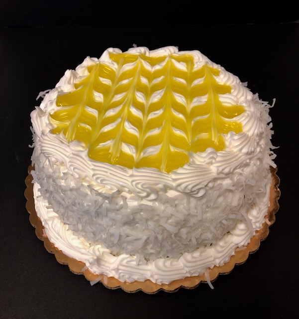 A white cake with yellow icing on top.