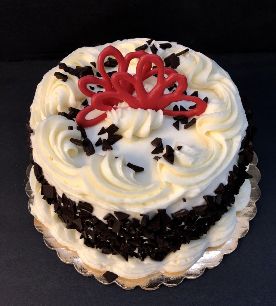 A black and white cake with a red bow on top.