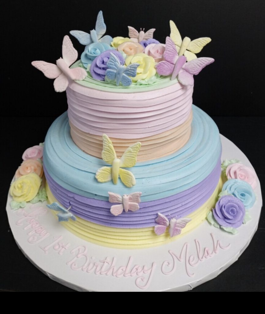 A birthday cake decorated with butterflies and flowers.