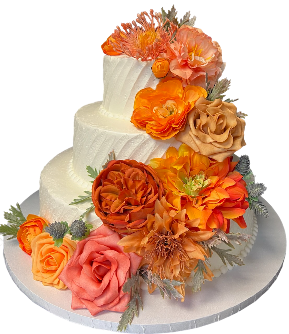 A three-tier white cake adorned with a variety of vibrant orange and pink flowers.